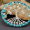 bottom view of tree roots as they are carefully attached to blue yarn wrapped metal hoop